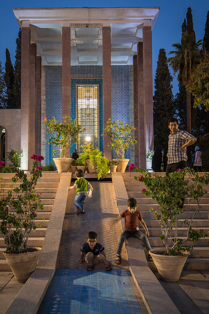 Kinder spielen vor Grabmal von Saadi in Shiraz, Iran, Asien