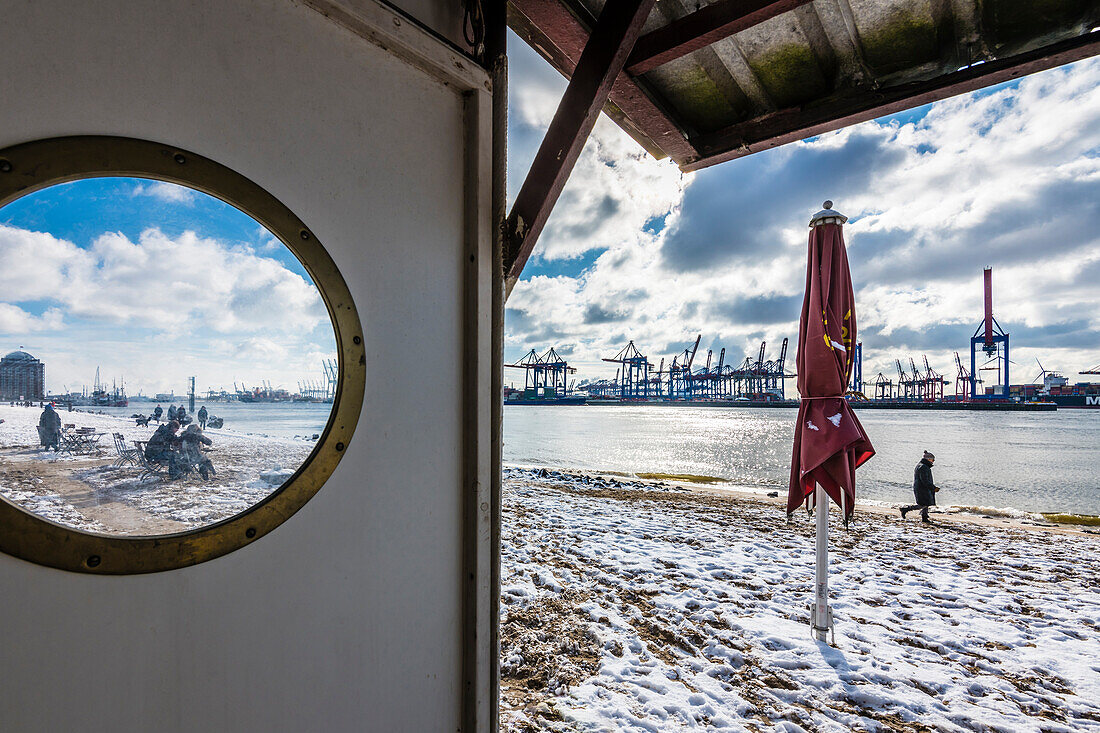Elbe Beach in winter with view at the container port Burchardkai, Hamburg, Germany