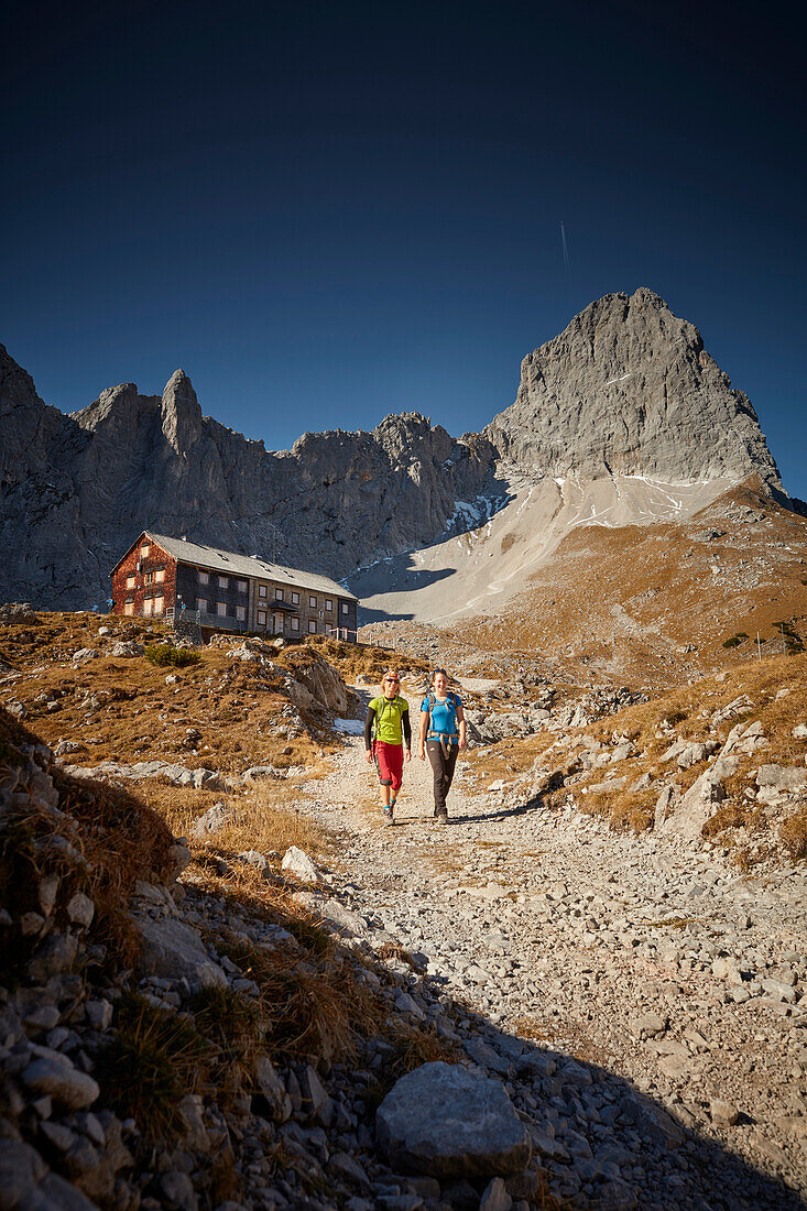 two women descending from Lamsenjoch alpine hut, Lamsenspitze in the back,  Eastern Karwendel Range, Tyrol, Austria