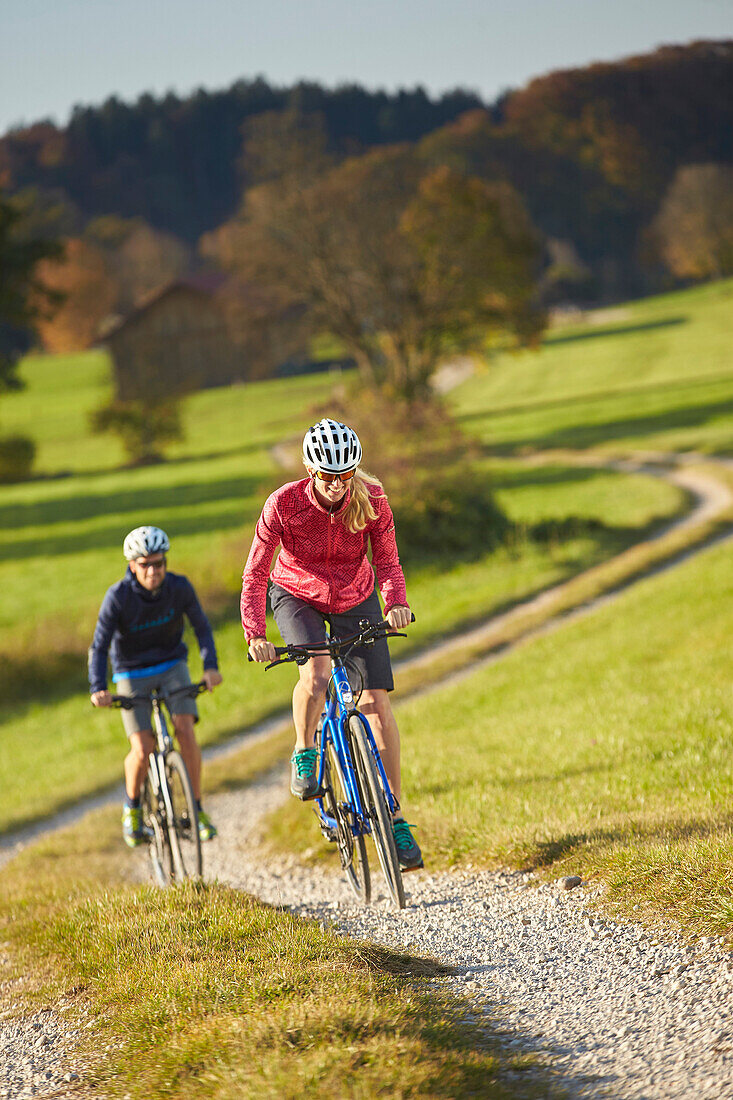 Young  woman young man on bicycle, Muensing, bavaria, germany