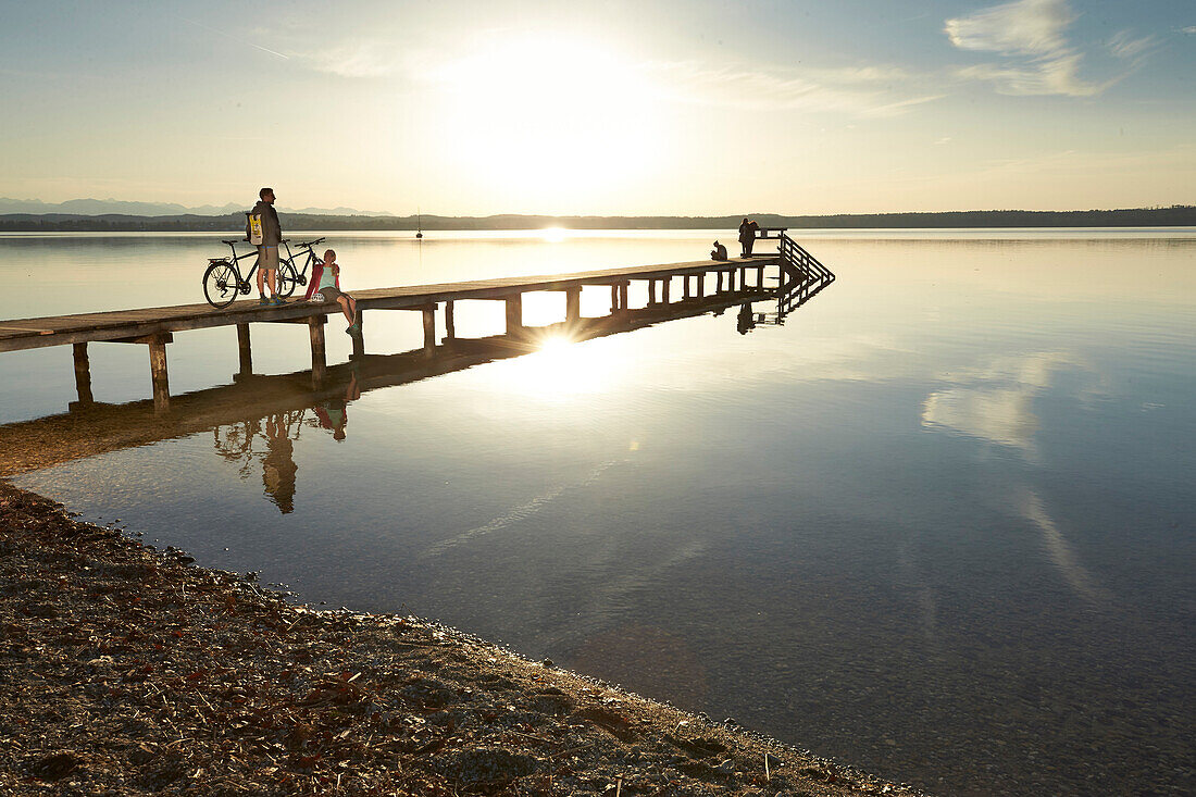 junge Frau junger Mann Paar mit Fahrrädern auf Steg am Seeufer, Münsing, Bayern, Deutschland