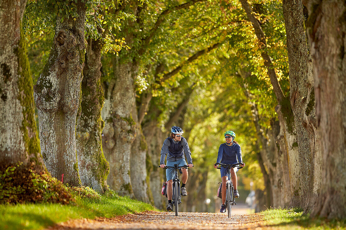 junge Frau auf Tourenrad und junger Mann auf eTourenfahrrad, Radtour, Münsing, Bayern, Deutschland