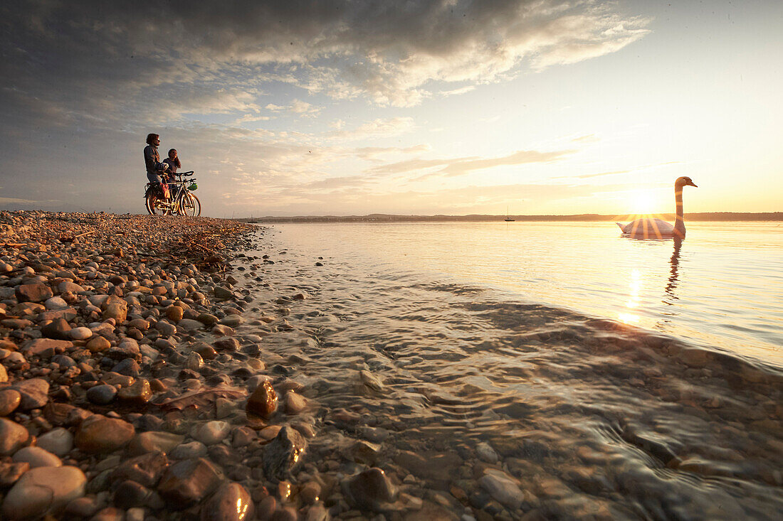 junge Frau auf Tourenrad und junger Mann auf eTourenfahrrad, Radtour am See, Münsing, Starnberger See, Bayern, Deutschland