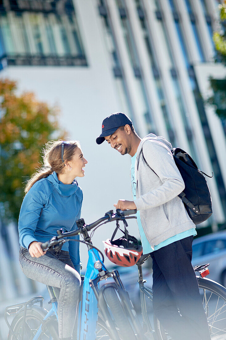 junge Frau und junger Mann Paar mit eBikes in der Stadt, München, Bayern, Deutschland