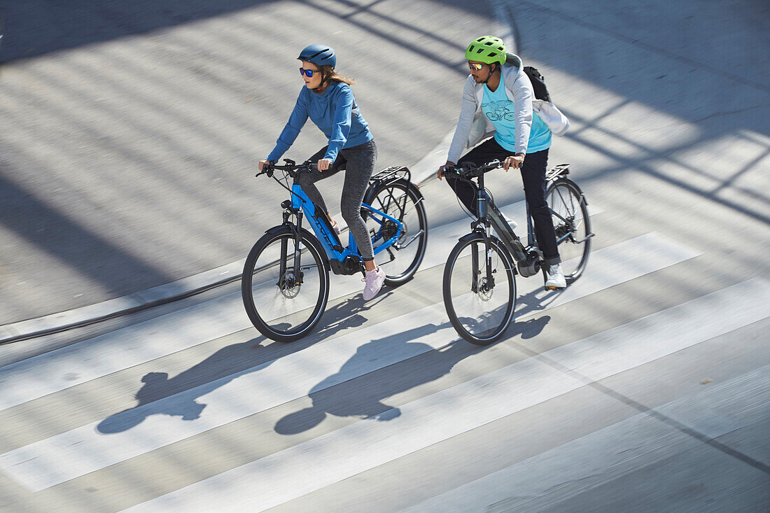 junge Frau und junger Mann Paar auf eBikes in der Stadt, München, Bayern, Deutschland