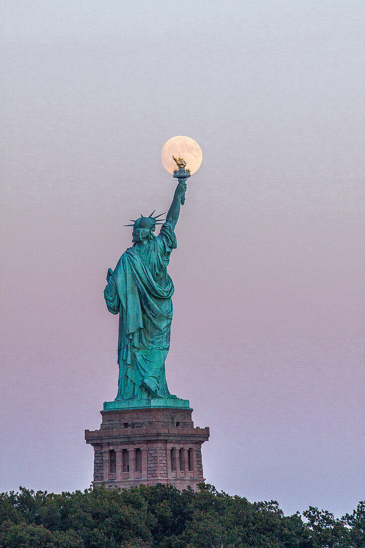 full moon rising over the statue of liberty in new york, monument listed as world heritage by unesco, new york city, new york, united states, usa