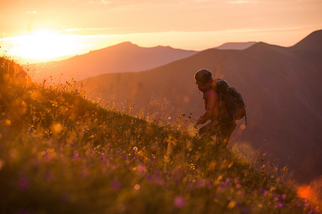 Bergsteigerin im Sonnenaufgang, E5, Alpenüberquerung, 1. Etappe Sperbachtobel, Kemptner Hütte, Allgäu, Deutschland