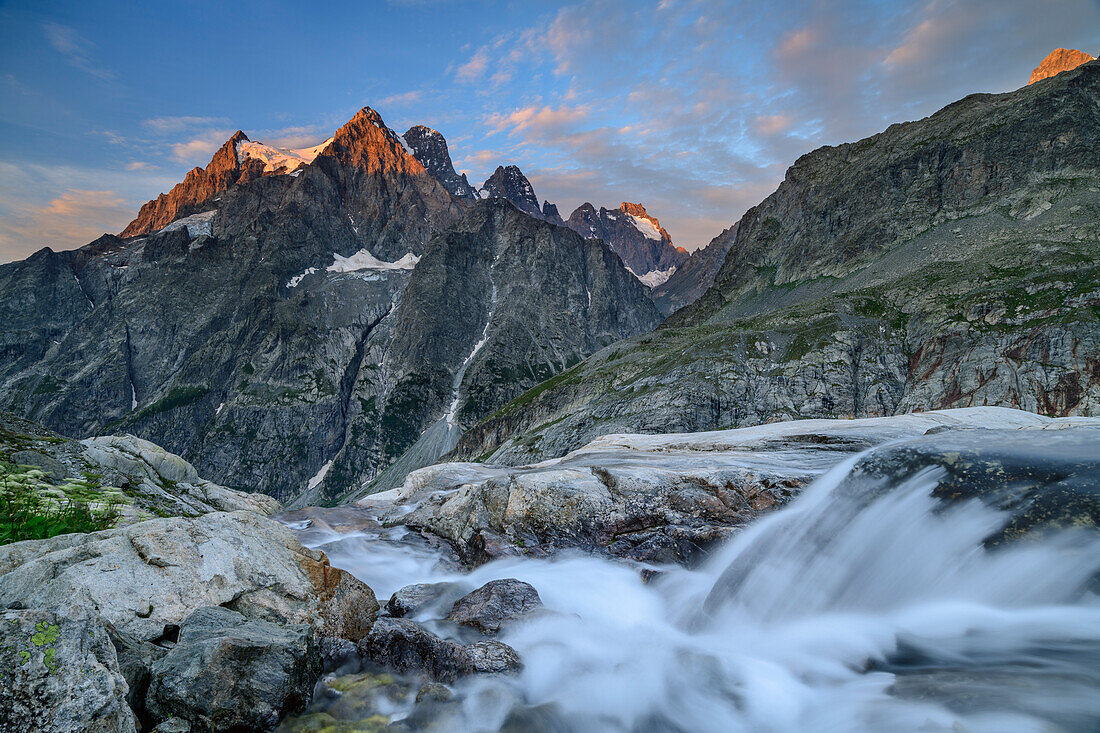 Bach fließt über Felsstufen, Mont Pelvoux im Alpenglühen im Hintergrund, Aufstieg zum Refuge Glacier Blanc, Ecrins, Nationalpark Ecrins, Dauphine, Dauphiné, Hautes Alpes, Frankreich