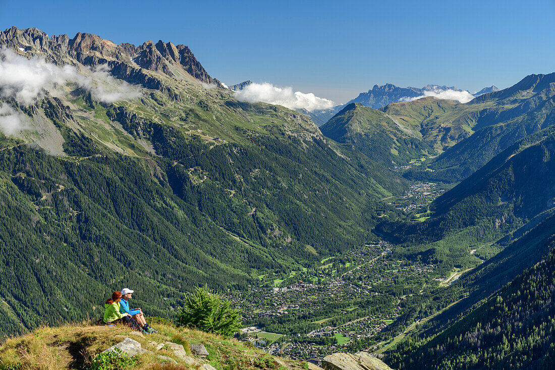 Mann und Frau sitzen auf Wiesenrücken, Chamonix im Hintergrund, Pyramide, Mont Blanc, Grajische Alpen, Savoyer Alpen, Haute-Savoie, Frankreich