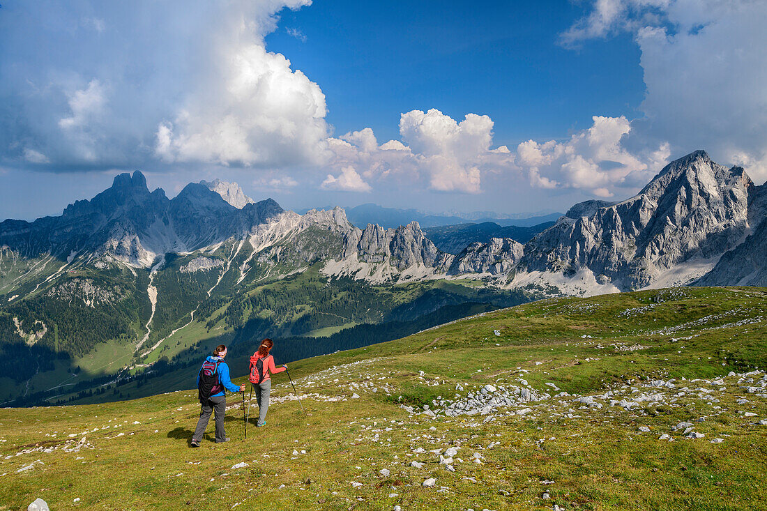 Two women while hiking, rising from the rötelstein Bischofsmütze and Gosaukamm Mountain in the background, rötelstein, Dachstein, Salzburg, Austria