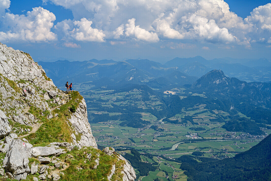 Zwei Frauen wandern auf ausgesetztem Wiesenband, Salzachtal im Hintergrund, Schustersteig, Hoher Göll, Berchtesgadener Alpen, Oberbayern, Bayern, Deutschland