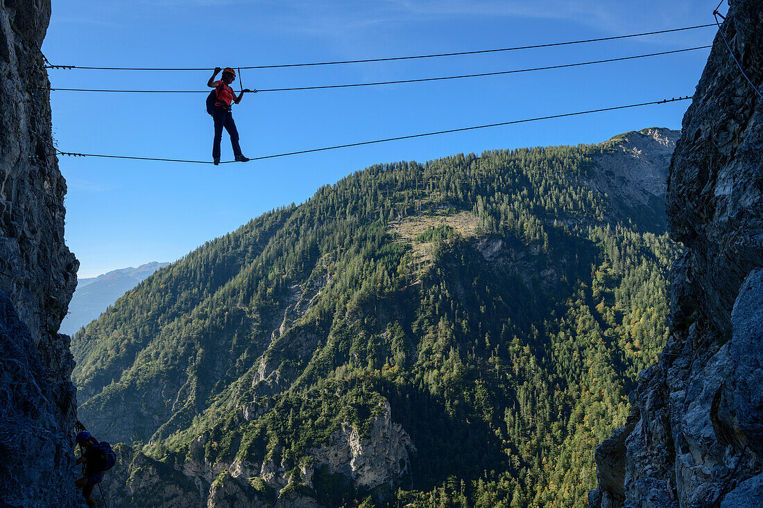 Frau steigt über Seilbrücke am Klettersteig zum Bettelwurf auf, Absamer Klettersteig, Bettelwurf, Karwendel, Tirol, Österreich