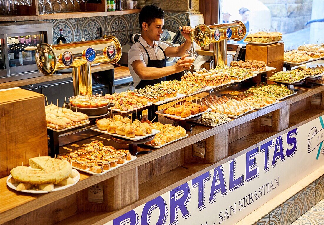 Kellner serviert Bier, Schinken, Pintxos, Bar Restaurante Portaletas, Parte Vieja, Altstadt, Donostia, San Sebastian, Gipuzkoa, Baskenland, Spanien