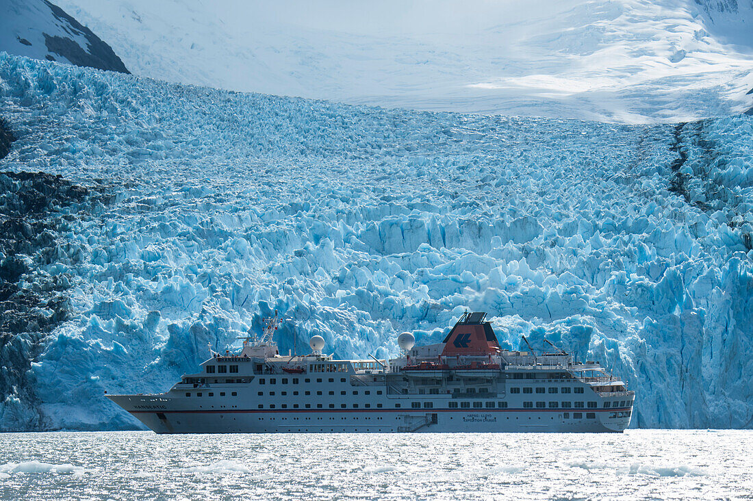 Expedition cruise ship MS Hanseatic (Hapag-Lloyd Cruises) lies at anchor in front of the massive glacier, Garibaldi Glacier, near Beagle Canal, Alberto de Agostini National Park, Magallanes y de la Antartica Chilena, Patagonia, Chile, South America