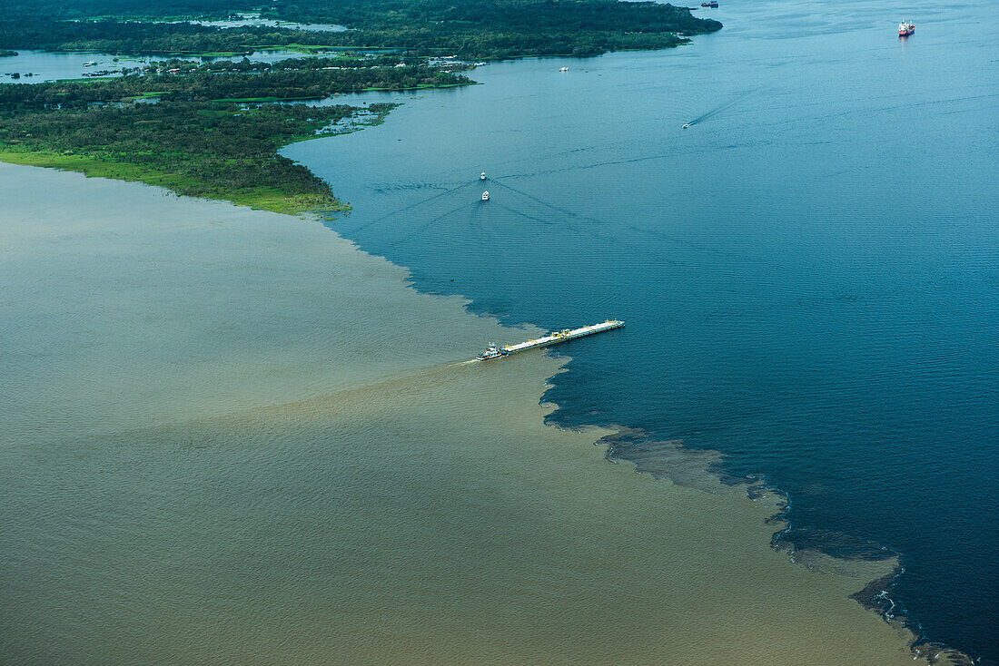 Der Rio Negro (rechts) trifft auf den Amazonas (auch Rio Solimões genannt), aber die Eigenschaften der beiden Wasserkörper verhindern ein schnelles Mischen und bilden so ein visuelles Meeting of Waters, Manaus, Amazonas, Brasilien, Südamerika