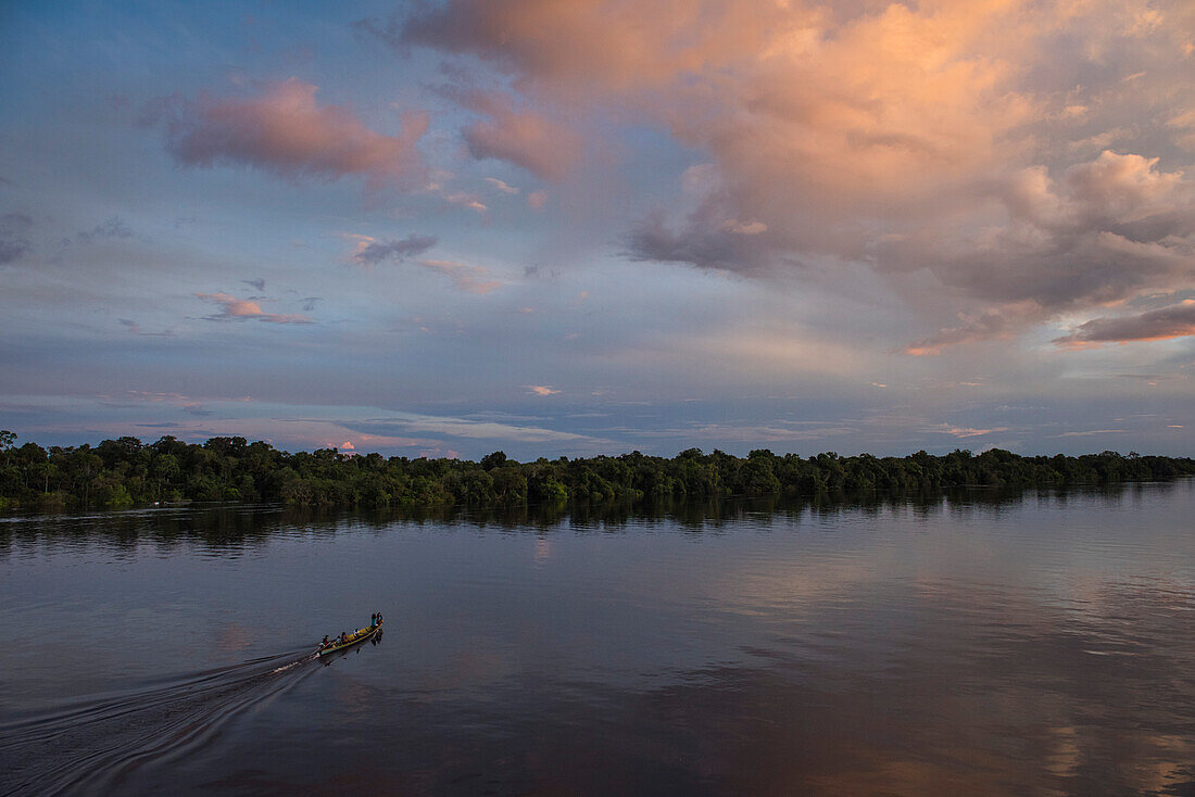 Ein motorisiertes Kanu mit fünf Passagieren kehrt am späten Nachmittag auf dem Amazonas nach Hause zurück, Jutai, Amazonas, Brasilien, Südamerika