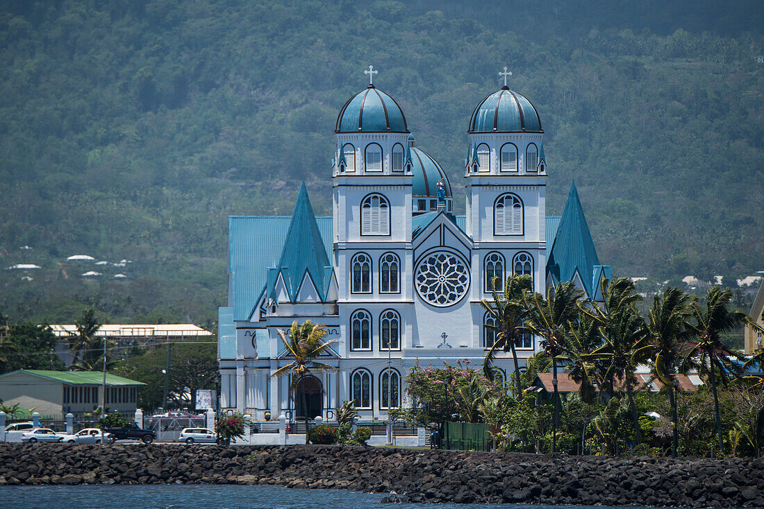 The blue, white and black Immaculate Conception Cathedral (also called Cathedral of Apia or Mulivai Cathedral), built on the site of the original mid-19th-Century church and opened in 2014, rises above nearby palm trees close to the shore, Apia, Upolu, Sa