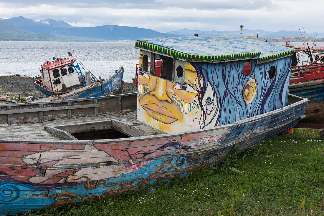 Creatively painted beached boats lie on the shore near the port, Puerto Williams, Magallanes y de la Antartica Chilena, Patagonia, Chile