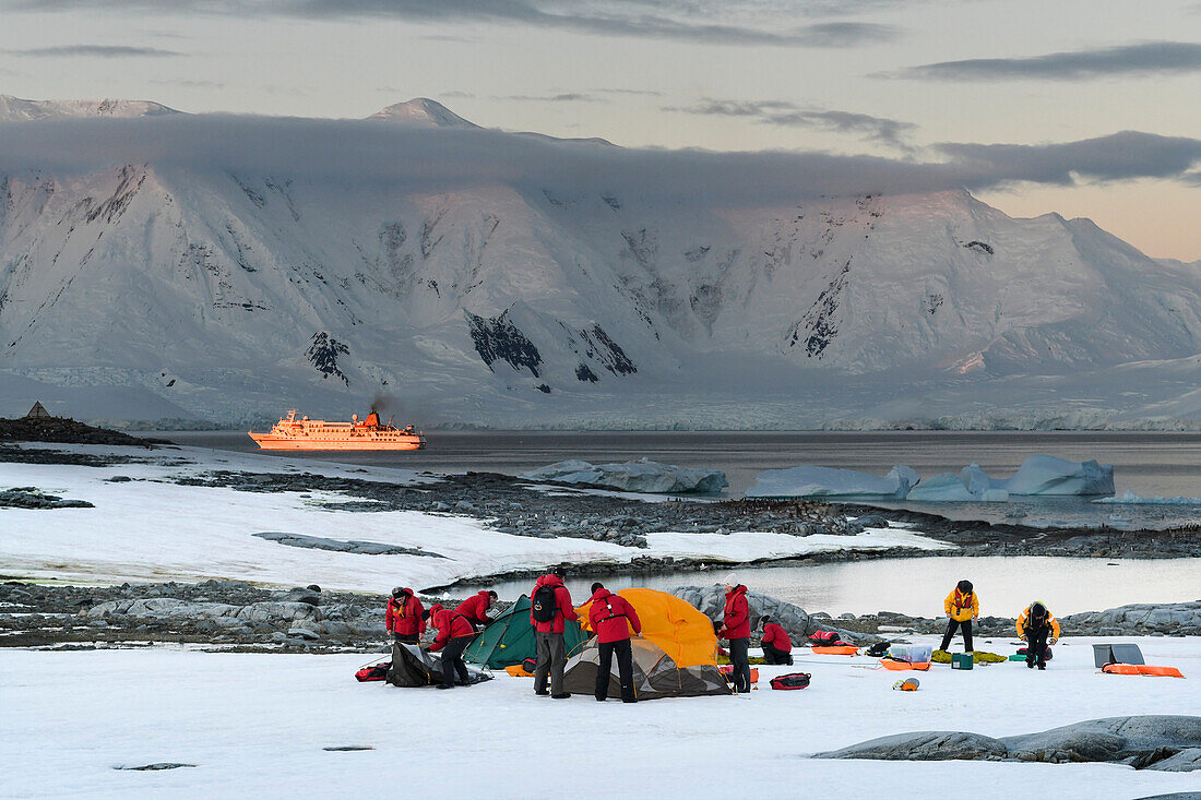 Die Passagiere von Expeditions Kreuzfahrtschiff MS Bremen (Hapag-Lloyd Kreuzfahrten) richten ihr Übernachtungslager auf einer flachen schneebedeckten Ebene aus, nahe Port Lockroy, Wiencke Island, Antarktis