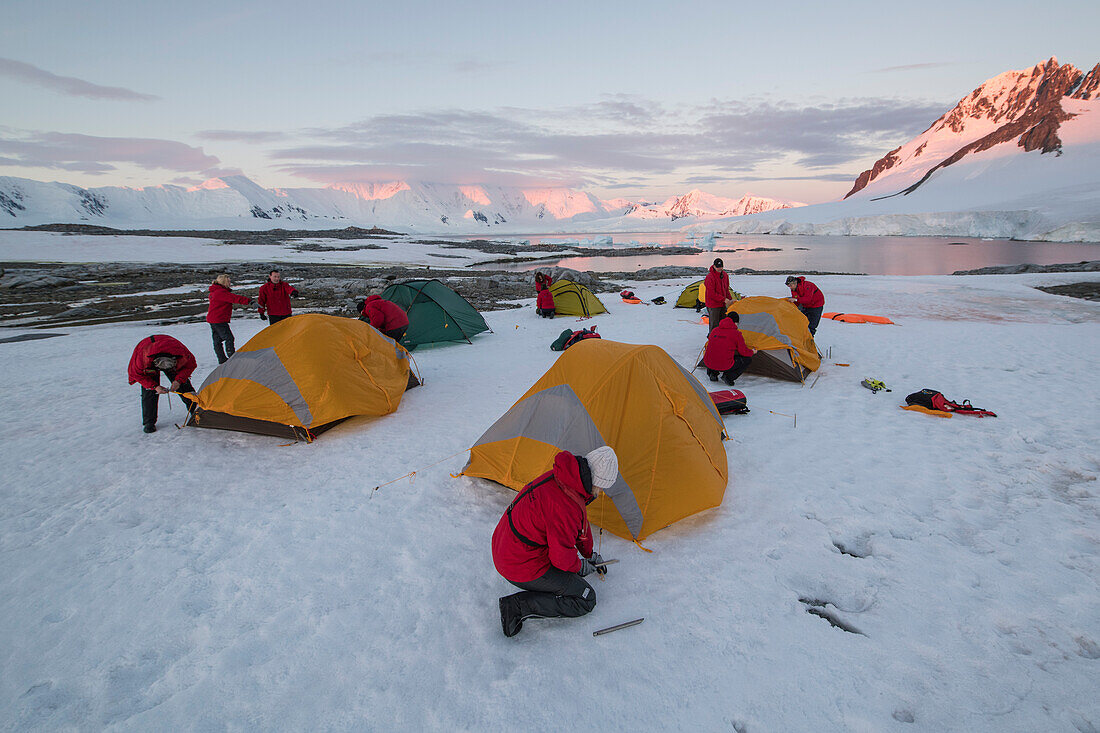 Die Passagiere von Expeditions Kreuzfahrtschiff MS Bremen (Hapag-Lloyd Kreuzfahrten) richten ihr Übernachtungslager auf einer flachen schneebedeckten Ebene aus, nahe Port Lockroy, Wiencke Island, Antarktis