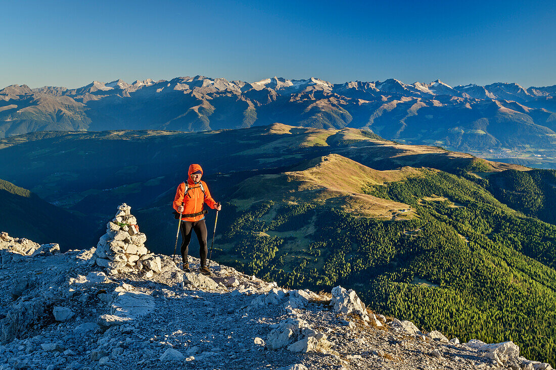 Man hiking ascending towards Peitlerkofel, Zillertal Alps in background, Peitlerkofel, Dolomites, UNESCO World Heritage Site Dolomites, South Tyrol, Italy
