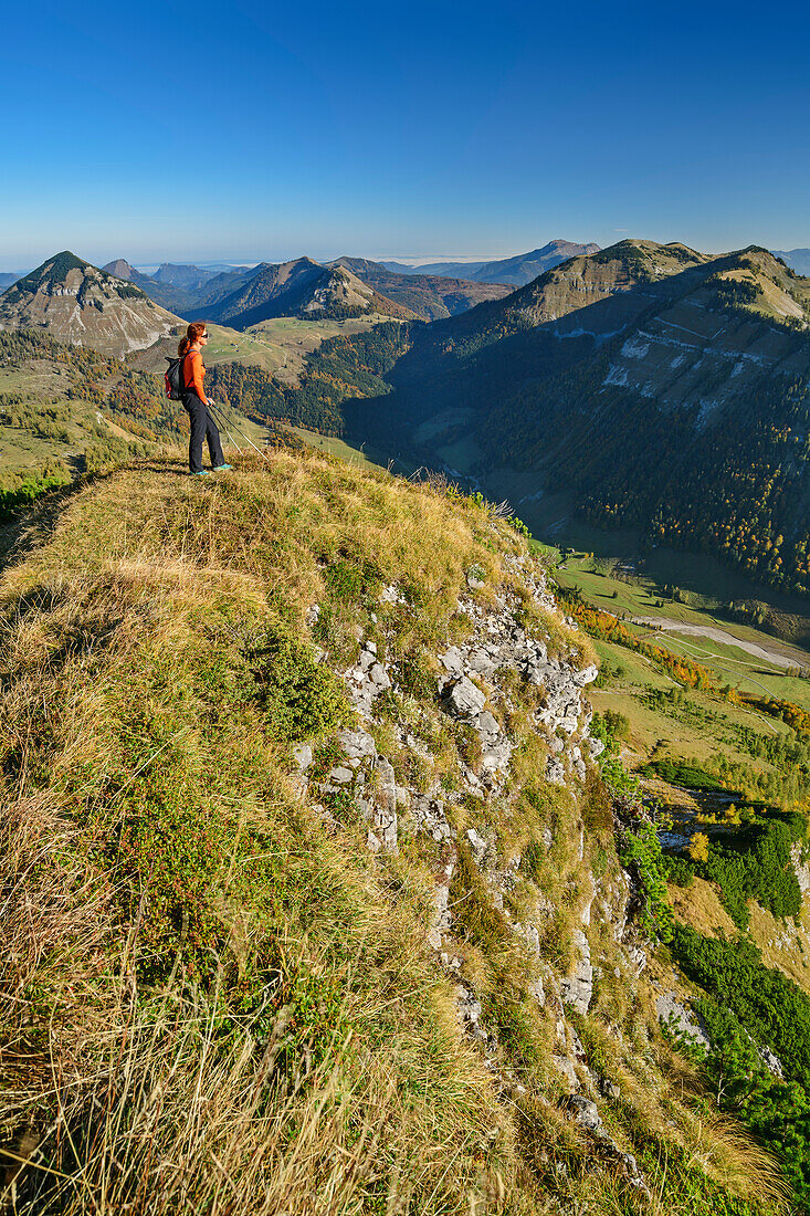 Woman hiking looking towards the valley, Salzkammergut Mountains in background, from Hochwieskopf, Salzkammergut, Salzburg, Austria