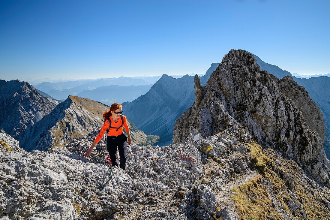 Woman hiking ascending on fixed-rope route towards Lamsenspitze, Lamsenspitze, Natural Park Karwendel, Karwendel range, Tyrol, Austria