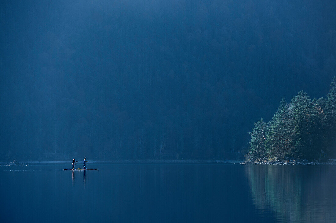 Stand-Up Paddlers riding at Eibsee below Zugspitze mountain, Grainau community, Garmisch-Partenkirchen, Bavaria, Alps, Germany