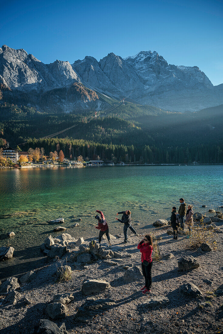 strollers throwing stones into Eibsee below Zugspitze mountain, Grainau community, Garmisch-Partenkirchen, Bavaria, Alps, Germany