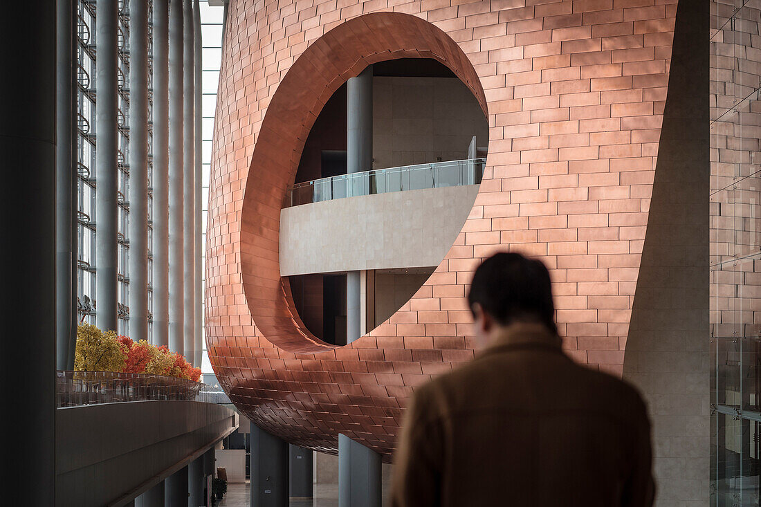 blurry Chineses man standing in front of architectural highlight inside China National Convention Centre , Beijing, China, Asia