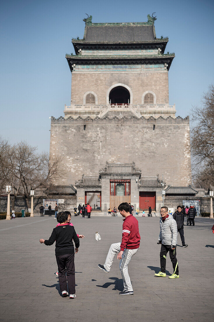 local Chinese people play football with shuttlecock ball at Bell Tower, Beijing, China, Asia