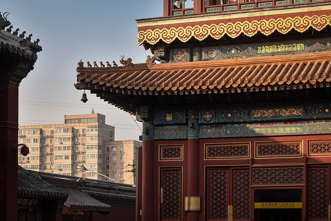 detail of roof art at Yonghe Temple (aka Lama Temple) with view at surrounding residential towers, Beijing, China, Asia