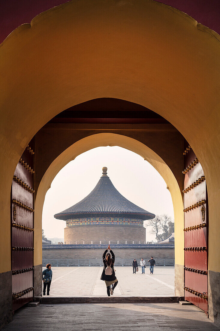 junge Chinesin posiert für ein Foto am Eingang zum Himmelstempel, Himmelsaltar, Bezirk Chongwen, Peking, China, Asien, UNESCO Welterbe