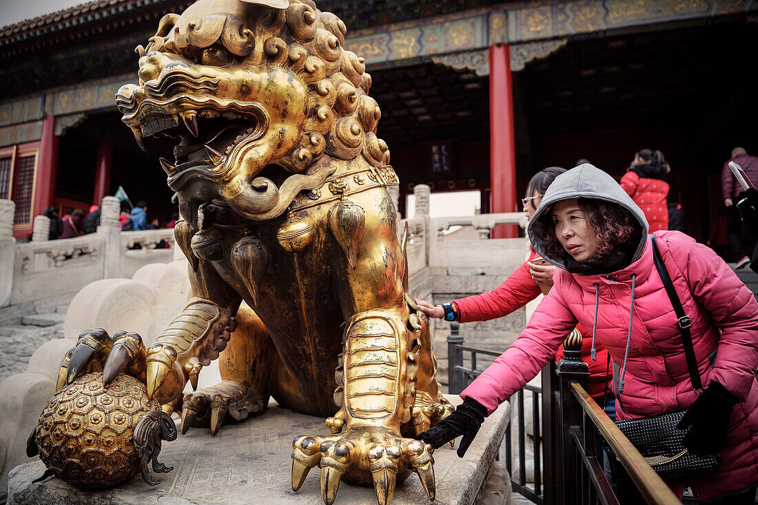 Chinesische Frau berührt Drachen Skulptur was Glück bringen soll, die Verbotene Stadt, Peking, China, Asien, UNESCO Welterbe