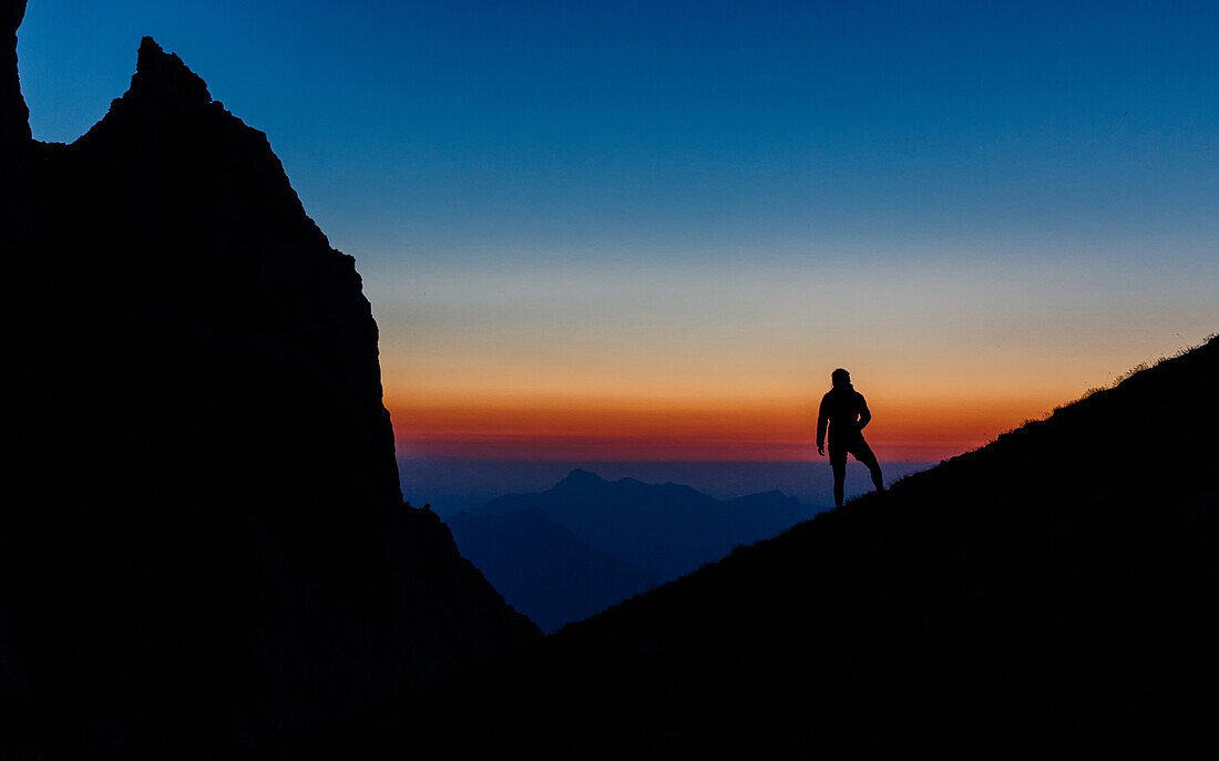 Junge Frau blickt vom Berg ins Tal bei Einbruch der Blauen Stunde, Silhouette, Scheffauer, Wilder Kaiser, Tirol, Österreich