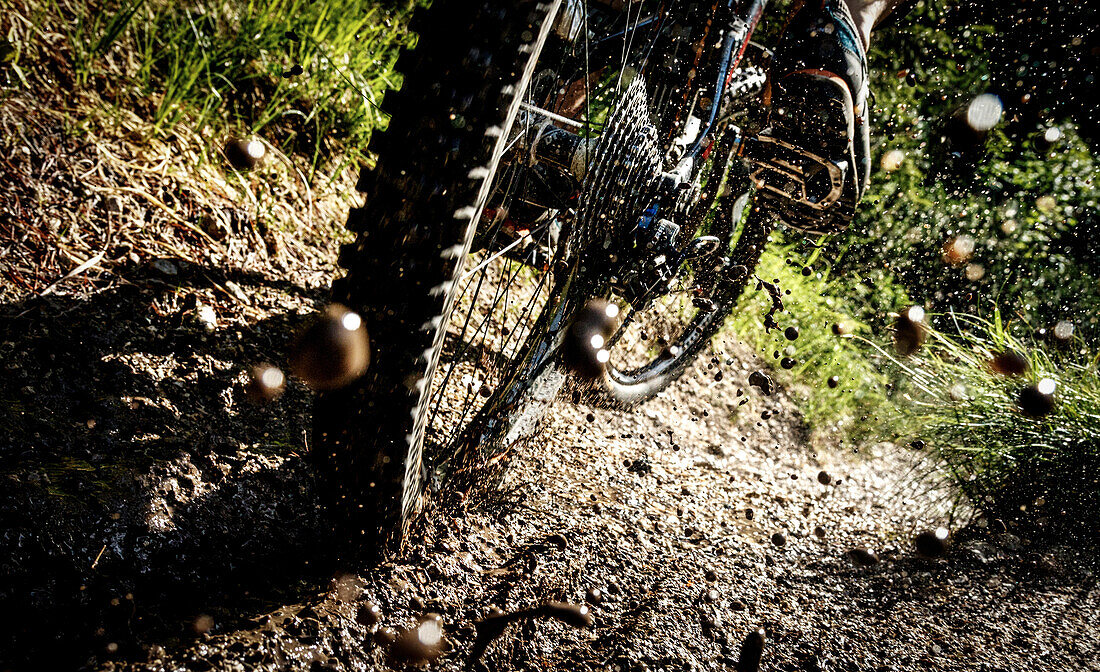 Rear wheel of a mountainbike in deep mud, sprinkling dirt, Tyrol, Austria