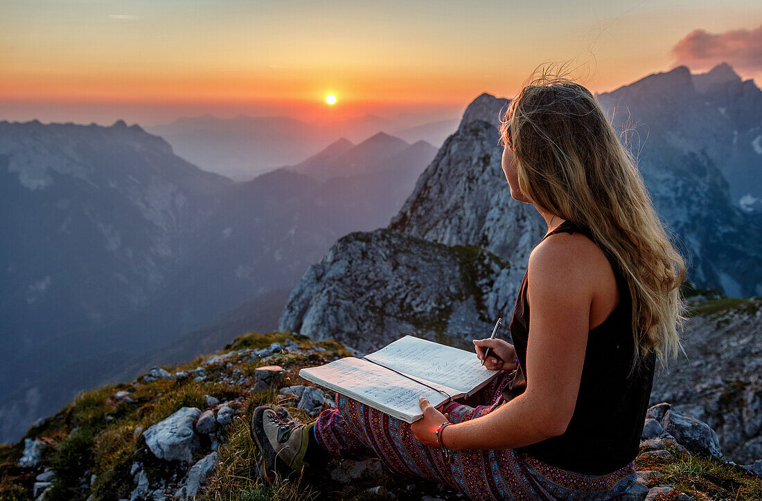 Junge Frau am Gipfel, Eintrag ins Gipfelbuch bei Sonnenaufgang, Scheffauer, Wilder Kaiser, Tirol, Österreich