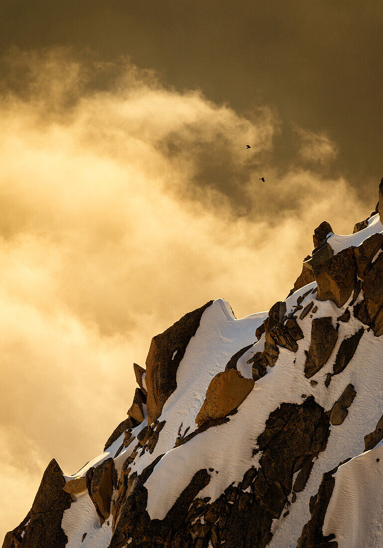 Rocky ridge at sunset, colorful clouds, two birds, Chamonix, Haute-Savoie, France