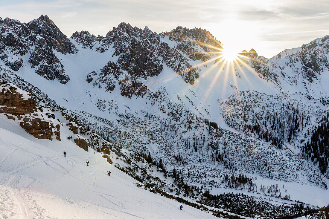 Gruppe Skitourengeher im Aufstieg mit Fellen durch Berghang im letzten Tageslicht, Scharnitz, Tirol, Österreich