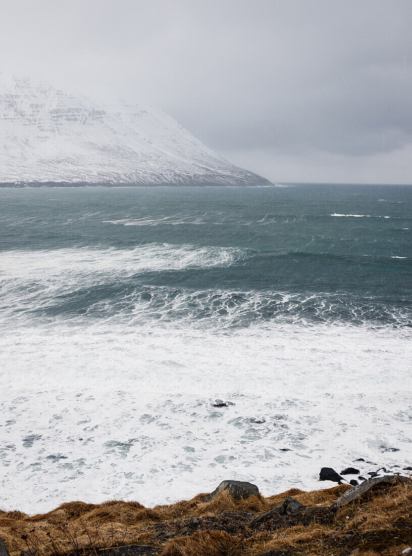Sturm an der Küste Tröllaskagis mit aufgepeitschtem Meer, umherziehenden Wolken, Winter, Island