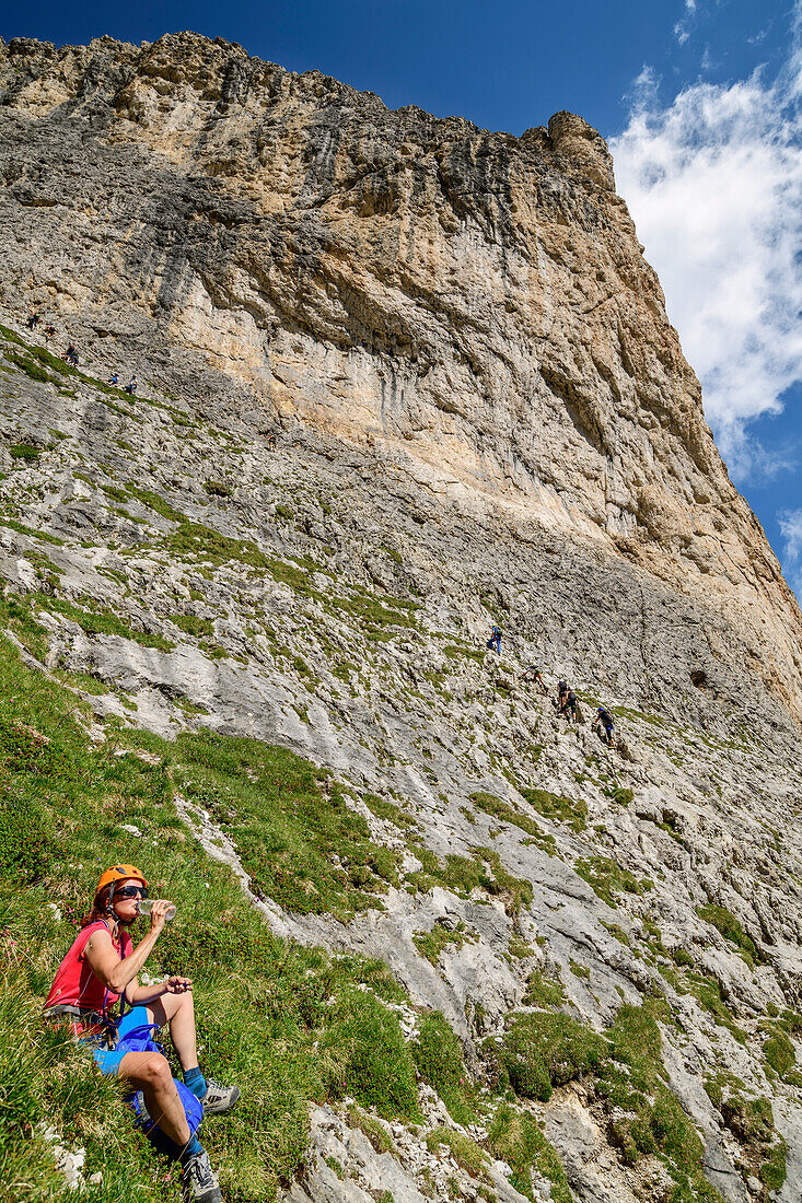 Frau macht am Pisciadu-Klettersteig Pause, Pisciadu-Klettersteig, Sella, Dolomiten, UNESCO Welterbe Dolomiten, Südtirol, Italien