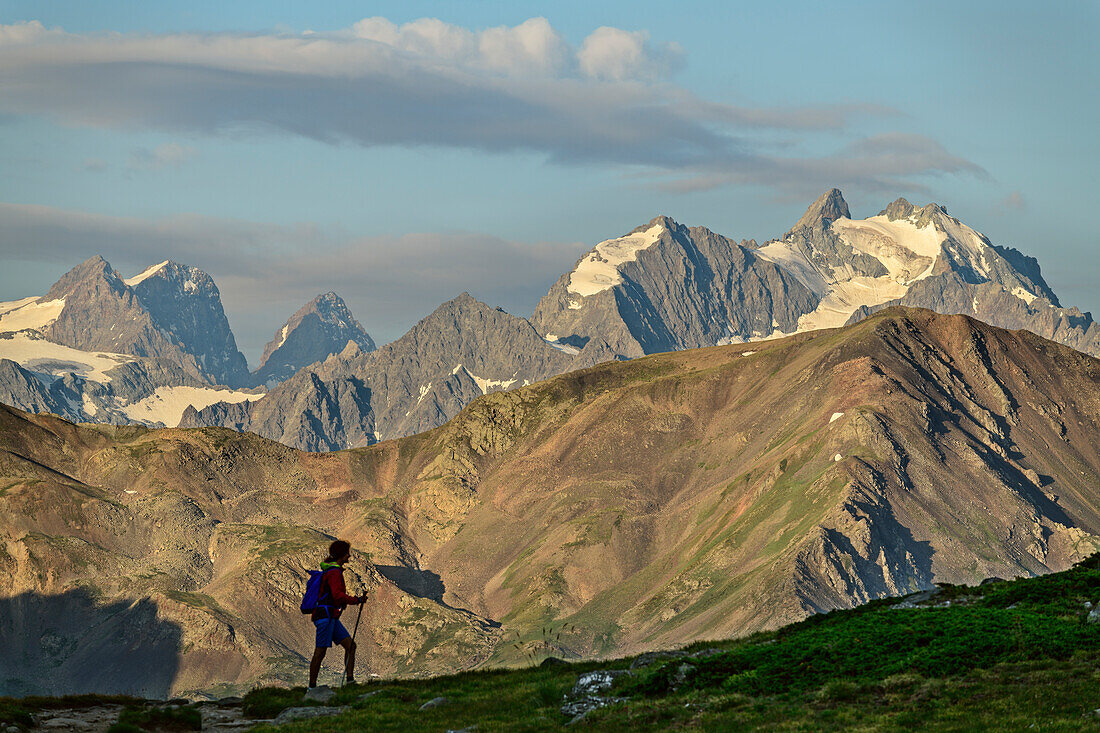 Woman hiking in front of glacier mountains of Ecrins, lake Lac du Serpent, Dauphine, Dauphiné, Hautes Alpes, France