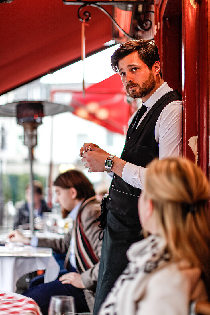 Waiter talking to a tourist at the La Mère Catherine restaurant, Place du Tertre, Montmartre, Paris, France, Europe