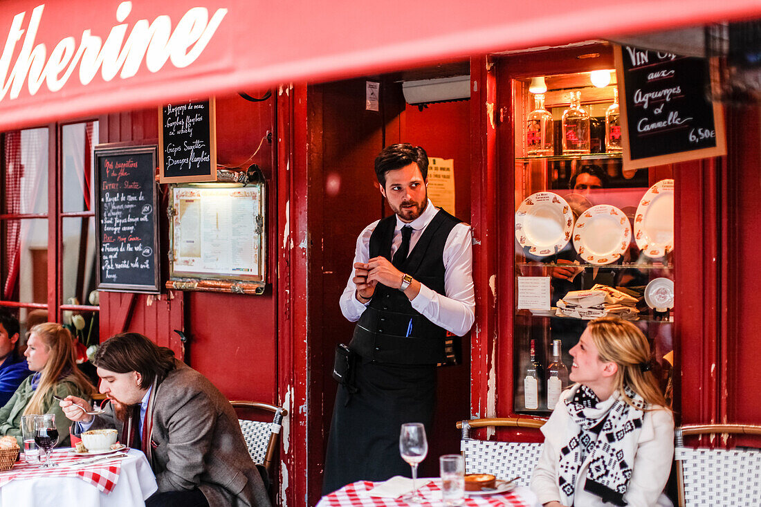 Waiter talking to a tourist at the La Mère Catherine restaurant, Place du Tertre, Montmartre, Paris, France, Europe
