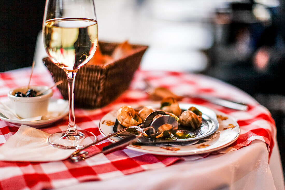 Escargots (snails) and a glass of white wine on the table in La Mère Catherine Restaurant, Place du Tertre, Montmartre, Paris, France, Europe