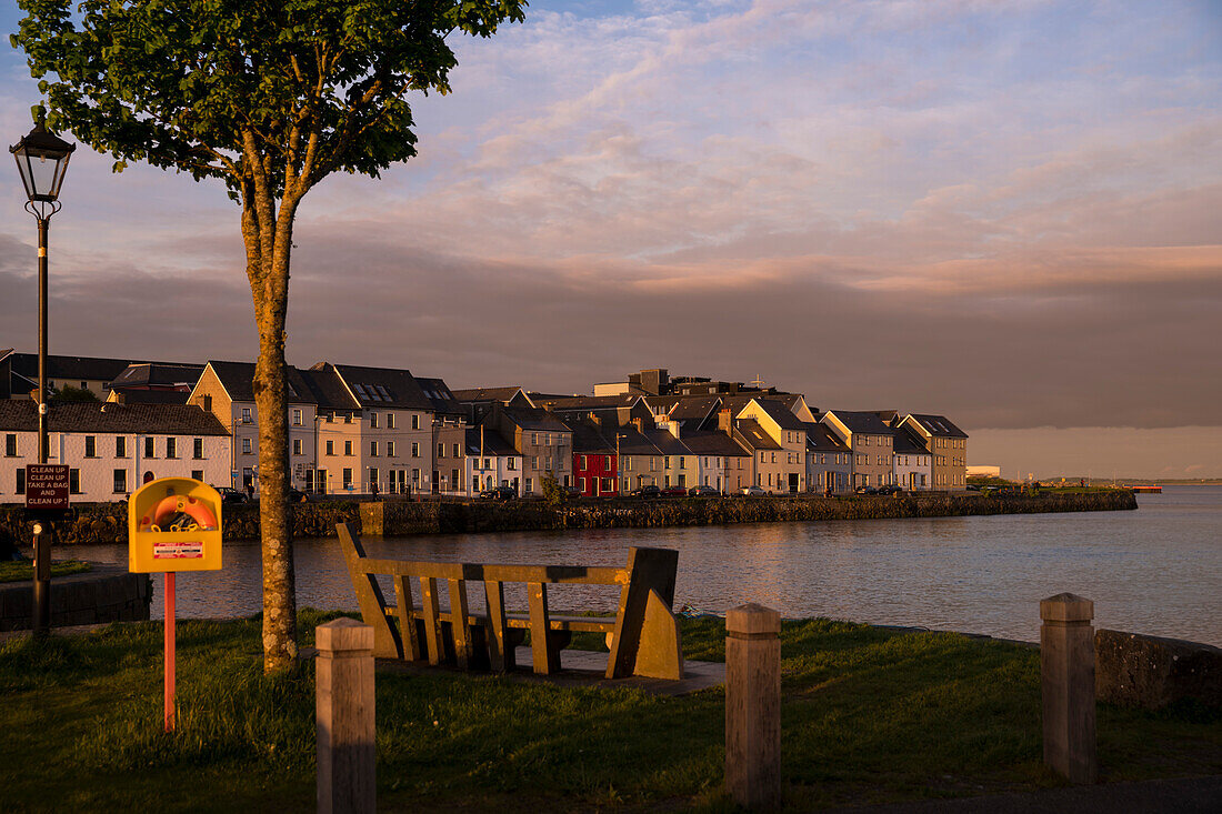 Der Sonnenuntergang färbt die Wolken am Himmel über der berühmten Häuserreihe am Straßenzug The Long Walk am Corrib Hafen rosa, Galway, County Galway, Irland, Europa