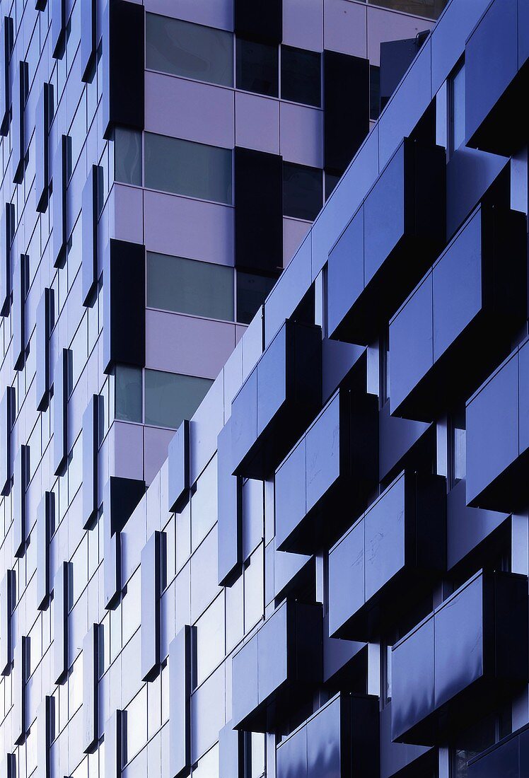 A facade of a newly built, multi-storey apartment block in the evening