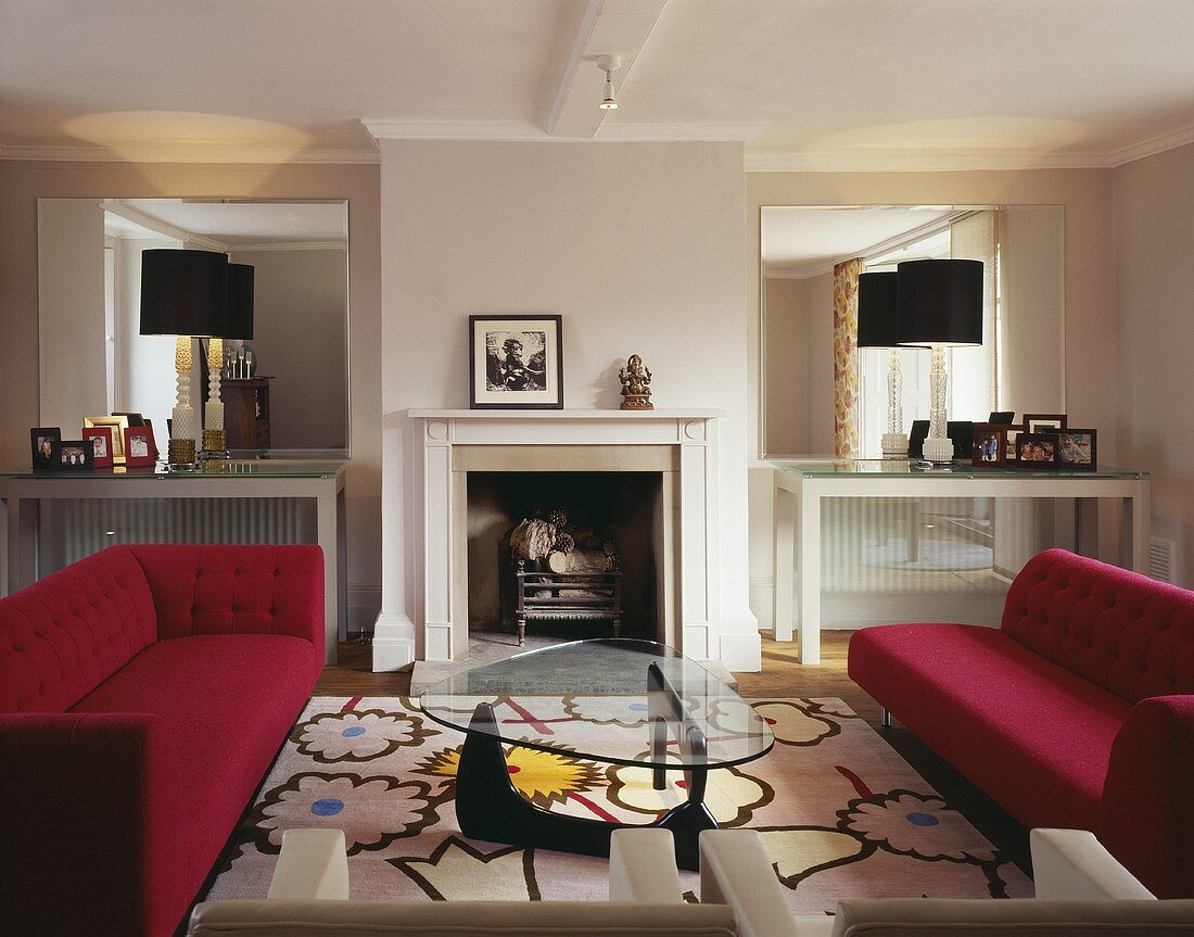 A living room in a period building with a fireplace and furniture in a mixture of styles from Bauhaus to modern