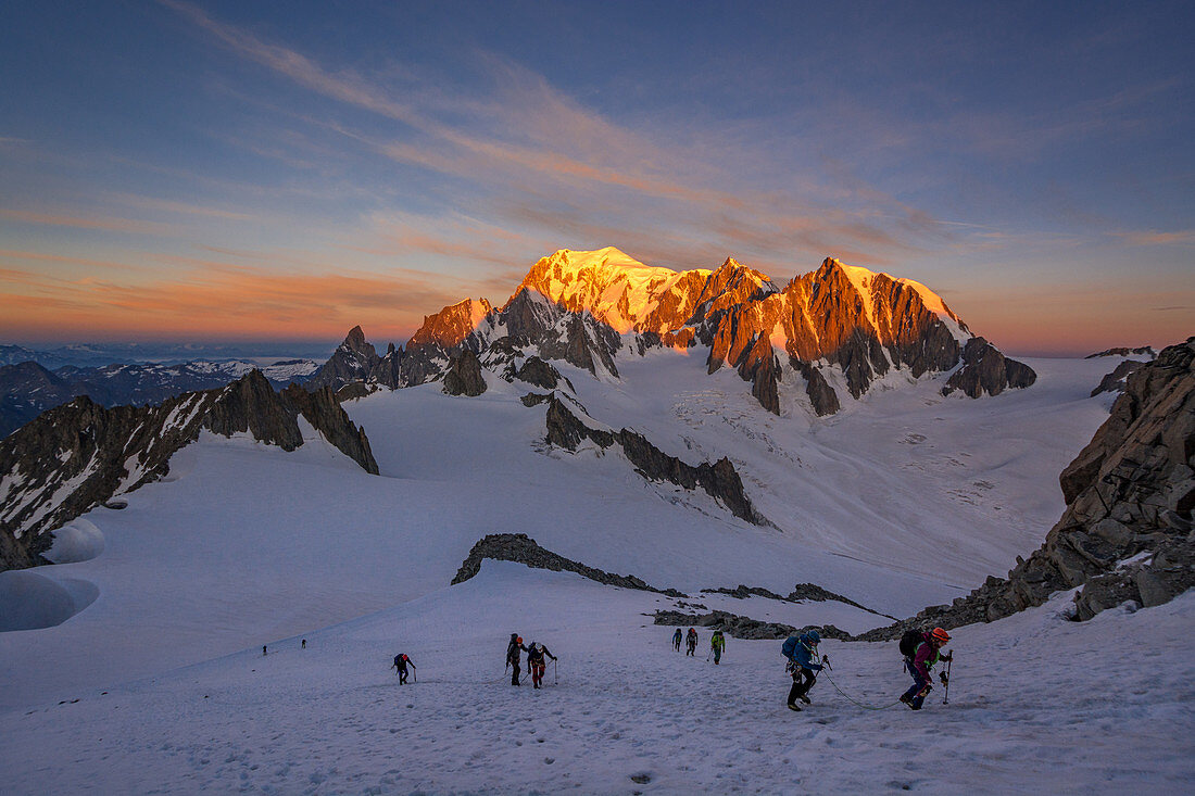 Bergsteiger während des Anstiegs zur Aiguille Rochefort, Sonnenaufgang am Mont Blanc im Hintergrund, Mont Blanc-Gruppe, Chamonix, Frankreich