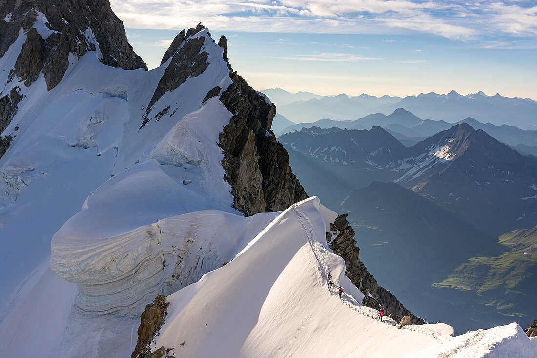 Bergsteiger bei der Überschreitung des Rochefortgrat vor einer Wechte, Aguille de Rochefort, Grandes Jorasses, Mont Blanc-Gruppe, Frankreich